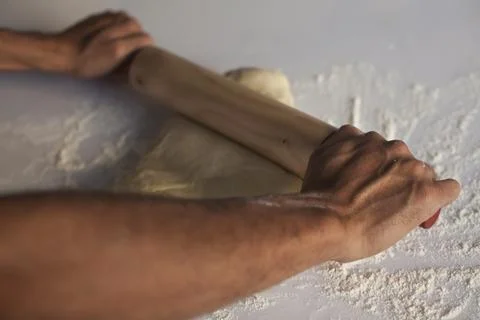 Hands making Raw and dry capeletti pasta on kitchen table Stock Photos