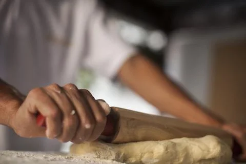Hands making Raw and dry capeletti pasta on kitchen table Stock Photos