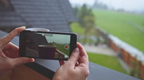 Hands Making a Smartphone video of Red Cup of Coffee Steaming Outdoors. 4K. Vidéo 66757084