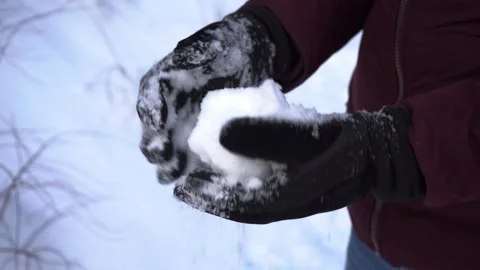 Hands making a snowball from fresh snow outdoors in winter gloves, no face  Stock-Footage 326824024