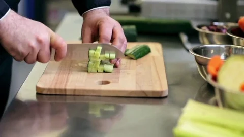 Hands of male cook chopping cucumber in kitchen Stock Footage