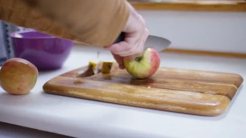 Hands of a male in the kitchen using a knife to cut apples Stock-Footage 101078425