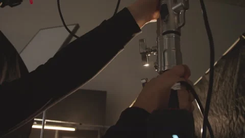 Hands of Male Technician Adjusting Stand with Reflective Umbrella before Shoot Stockbeeldmateriaal 254375707