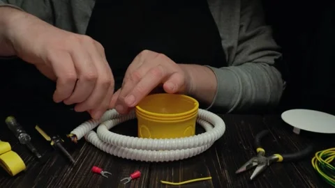 Hands of a male technician assembling electrical components with yellow plastic Stock Footage 336505132