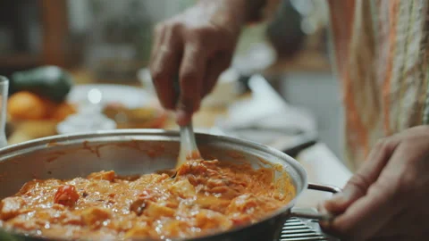 Hands of Man Adding Lime Juice and Stirring Paneer Butter Masala in Pan Stock Footage 303018298