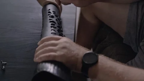 Hands of Man with Amputation Preparing Carbon Fiber Prosthesis for Use Stockbeeldmateriaal 317900591