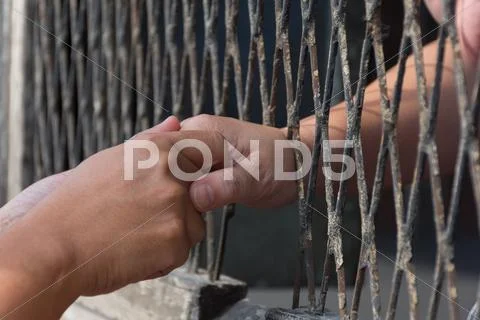 Hands of the man and woman on a steel lattice Stock Photos