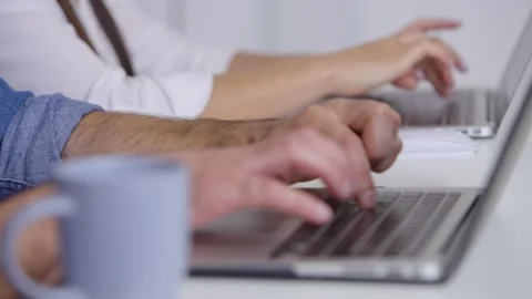 Hands of a man are typing on a laptop, then the focus is on the hands of a woman Video stock 236588688