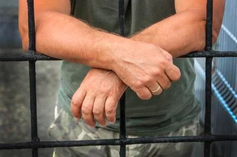 Hands of a man behind bars prisons Stock Photos