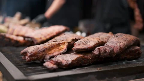 Hands of a man in black gloves rotating a barbecue on the fire Stock Footage 186641603
