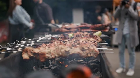 Hands of a man in black gloves rotating a barbecue on the fire Stock Footage 186642443