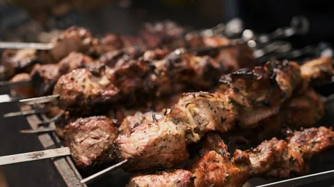 Hands of a man in black gloves rotating a barbecue on the fire Stock Footage 186646340
