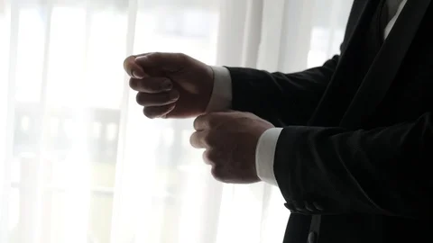 Hands of a man in a black suit that fastens and straightens the sleeves Stock Footage