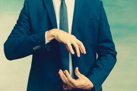 Hands of a man in a blue jacket folded in the shape of a sphere or as if pull Stock Photos