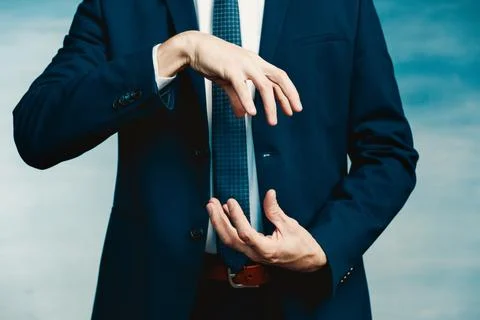 Hands of a man in a blue jacket folded in the shape of a sphere or as if pull Stock Photos