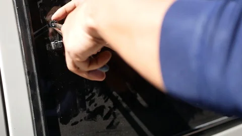 Hands of a man breaking a side window lock of a van - vehicle crime Stock Footage 130017934