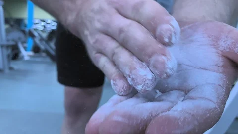 Hands of man clapping magnesia in slow motion.  Preparing to lift barbell Stock-Footage 117938323