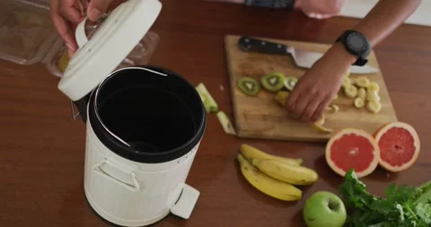Hands of man composting vegetable waste in kitchen Stock Footage 339412515