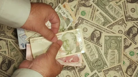 Hands of a man counting Turkish lira banknotes against a background of US d.. Stock Footage 318098244