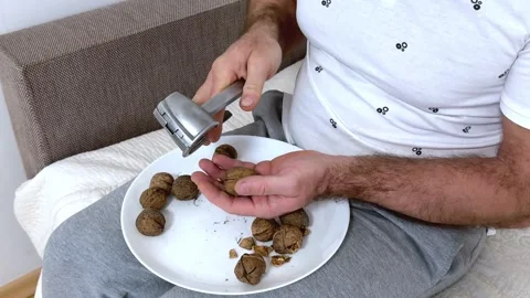 Hands of a man cracking walnuts with a nutcracker Stock Footage 323186434