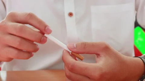 Hands of a man cutting a cigarette in two halves with scissors. Stop smoking  Stock Footage 108253344