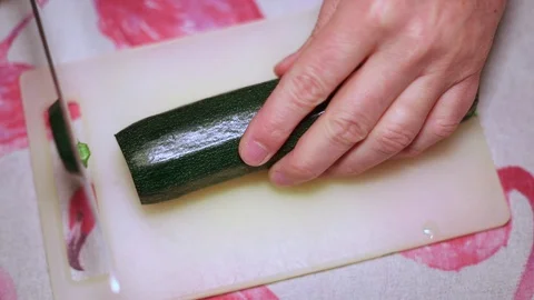 Hands of a man cutting a courgette Stock Footage 128822718