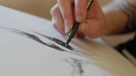 Hands of man drawing with black pencil on white paper Stock Footage 268730948