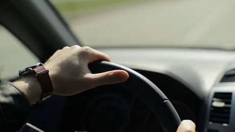 Hands of a man driving a car Stock Footage 73998827