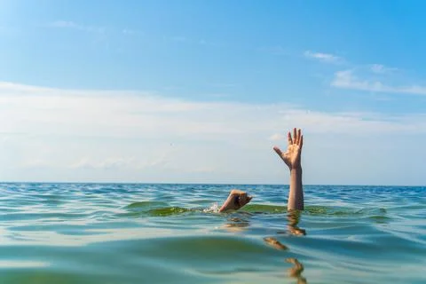 The hands of a man drowning in the sea Stock Photos