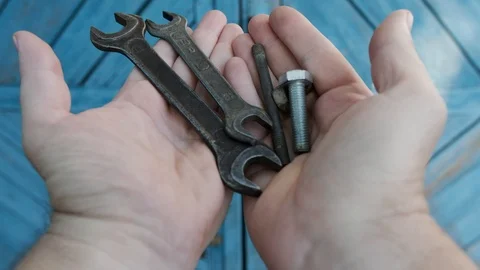 Hands of a man dump various tools on a blue wooden background Stock Footage 91329522
