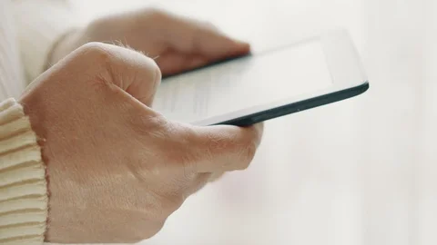 Hands of a man with an e-book near the window. Soft focus Stock Footage 128852767
