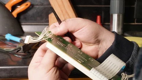 Hands of man handling green electrical card and preparing it for setting new Stock Footage 108105104