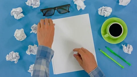 Hands of a man holding blank sheets. Top view of the writer's table Stock-Footage 77374241