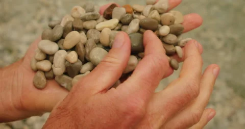 Hands of man holding heap of smooth sea pebbles at Marina Piccola beach in Capri Stock-Footage 327756087