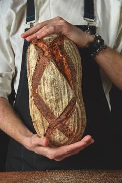 Hands of man holding oval bread 스톡 사진