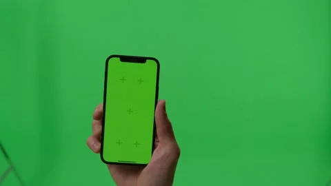 Hands of man holding a phone with vertical green chroma key screen. isolated on Video stock 201289161