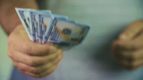 The hands of a man holding several hundred dollar bills. Stock Footage 337700583