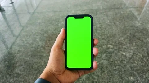 Hands of a man holding a smartphone touching the phone with a vertical green Stock-Footage 303506235