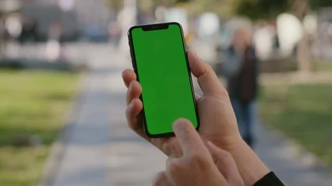 Hands of man holding vertical smartphone using green chrome key screen with Stock Footage 117426895
