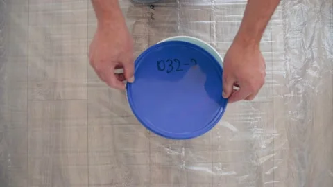 Hands of a man I open the lid on a bucket of paint Blue paint Home repair Video stock 152884900