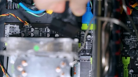 Hands of a man inserts a plug into the power connector of the motherboard Stock-Footage 121758059