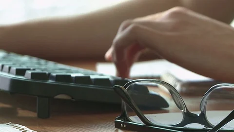 Hands of the man on the keyboard, working at the computer, near on the table lie Stock Footage 85486411