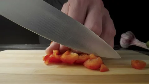 Hands of man with knife dicing red sweet pepper. Process of cutting bell peppers Stock Footage 203017541