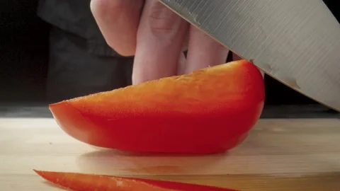 Hands of man with knife slicing red sweet pepper into long pieces. Process of Stock Footage 203017357