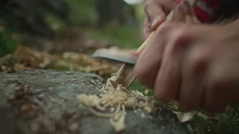 Hands of Man Making Feather Sticks with Knife to Start Fire in Wilderness Stock Footage 317337821