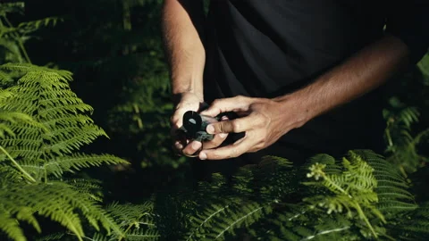 Hands of a man opens the compass in the mountains to orient himself in the hike Stock Footage 201291051