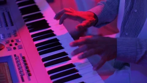 Hands of a man playing a synthesizer in the light Stock Footage 80896307