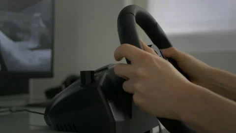 Hands Of A Man Playing Video Game With A Steering Wheel Stock Footage