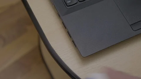 Hands of a man plugging in and out an usb stick on his laptop placed on the t Stock Footage 87014101