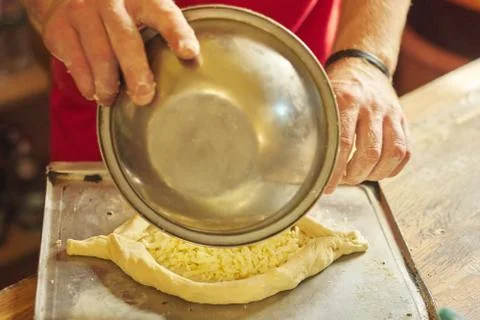 Hands of man preparing khachapuri, on the table flour dough cheese Stock Photos